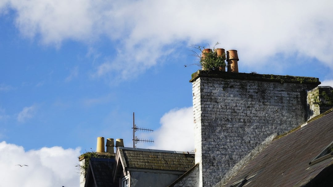 Chimneys on old rooftops against a cloudy blue sky