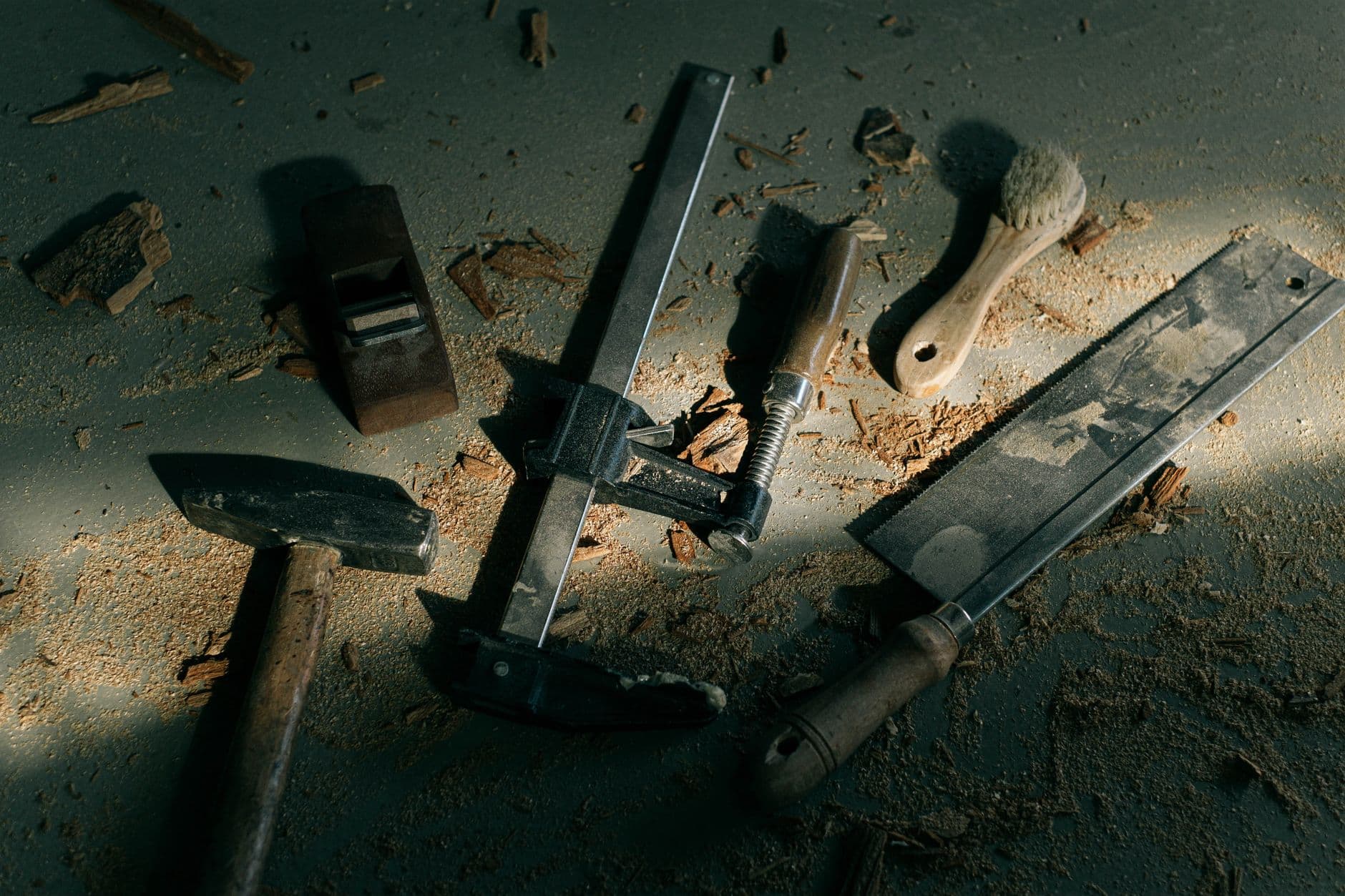 Vintage woodworking tools on a dusty workshop floor, evoking craftsmanship.